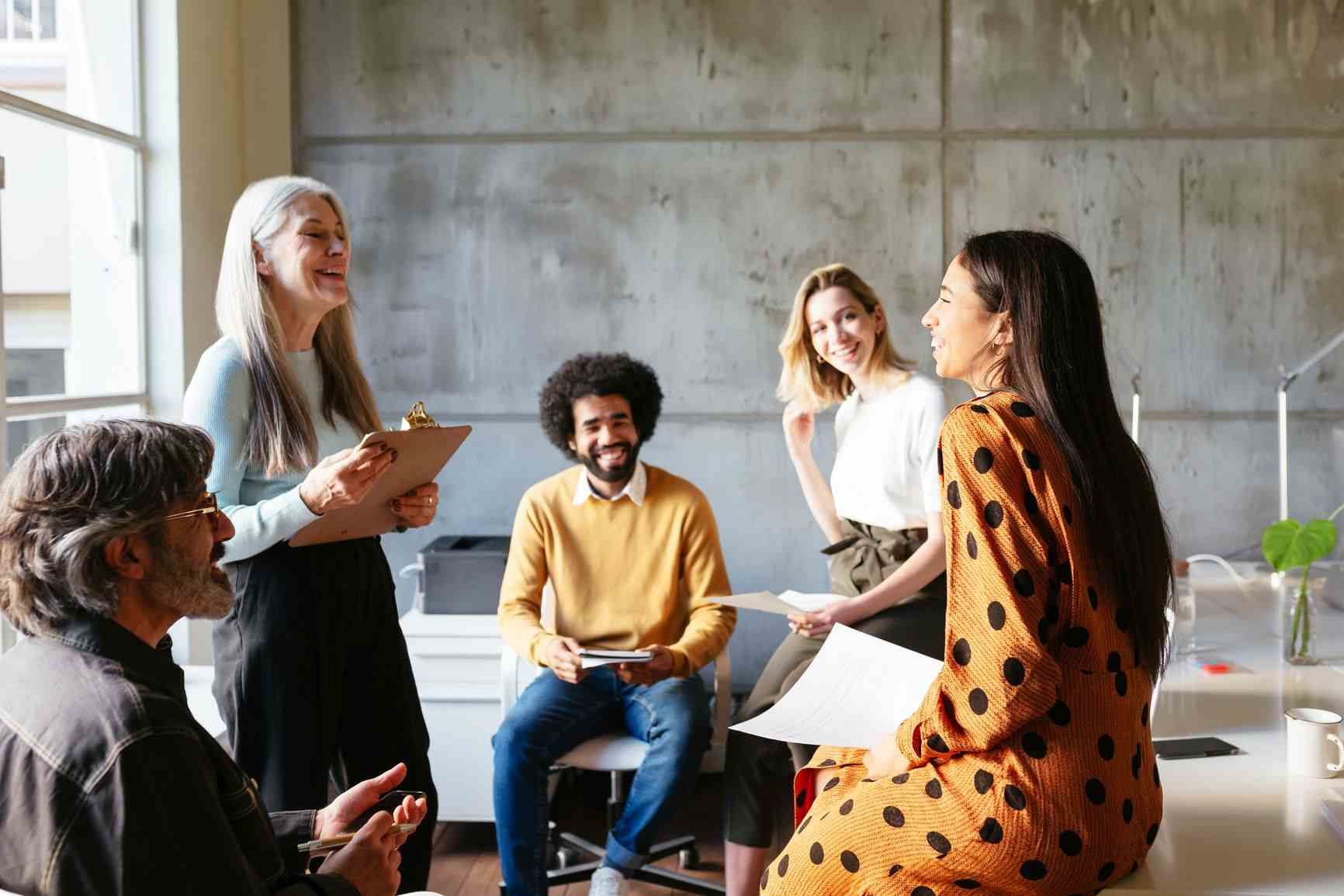 Office workers laughing and happy at work, which helps with employee retention