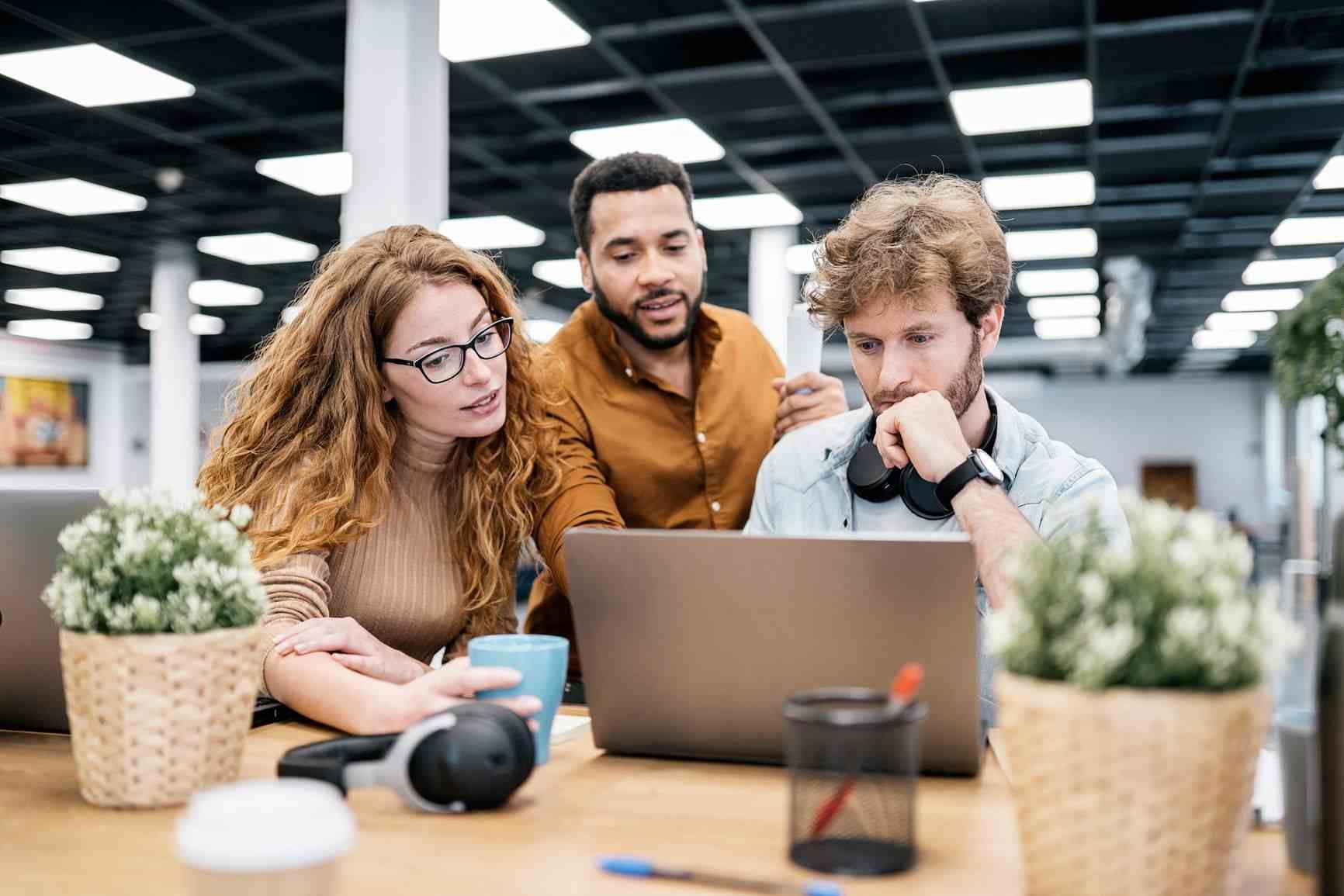 Office workers laughing and happy at work, which helps with employee retention