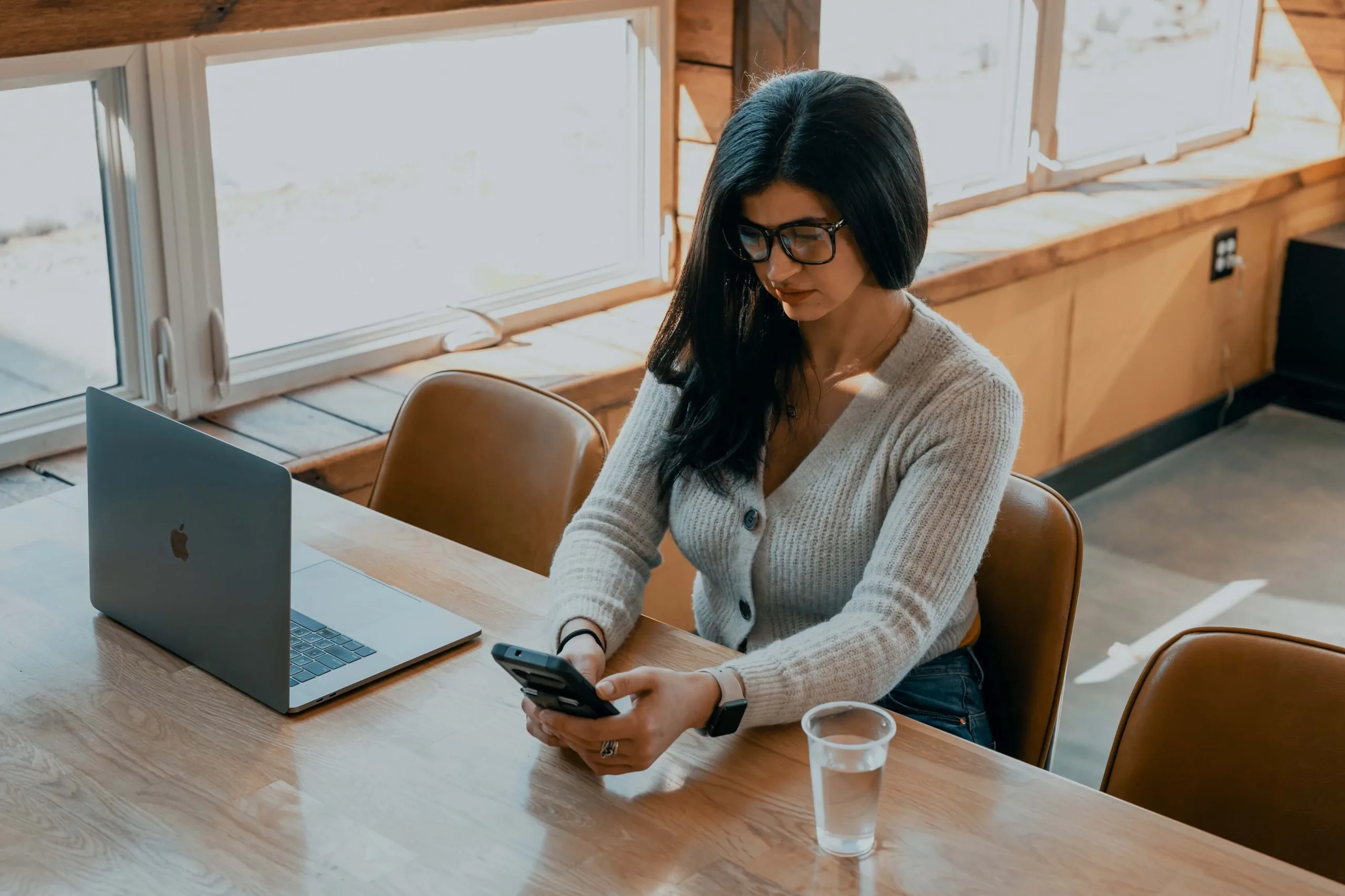 woman at table receives text message