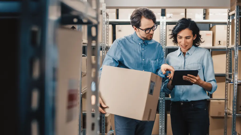 man and woman holding boxes-in-warehouse