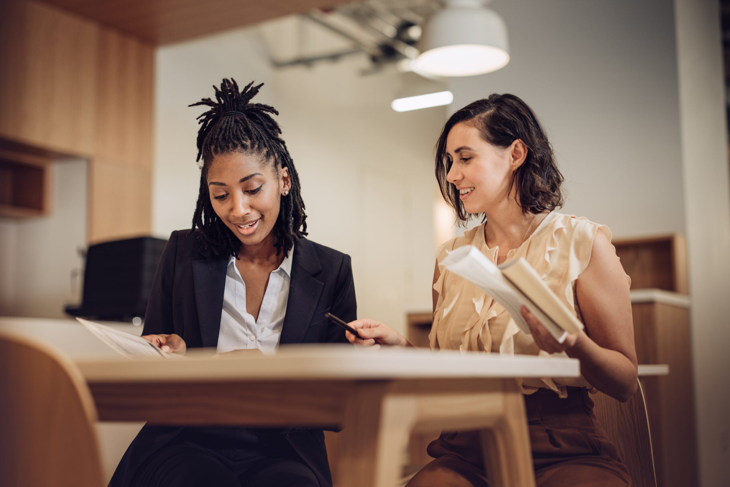 Two women sitting at a table in an office